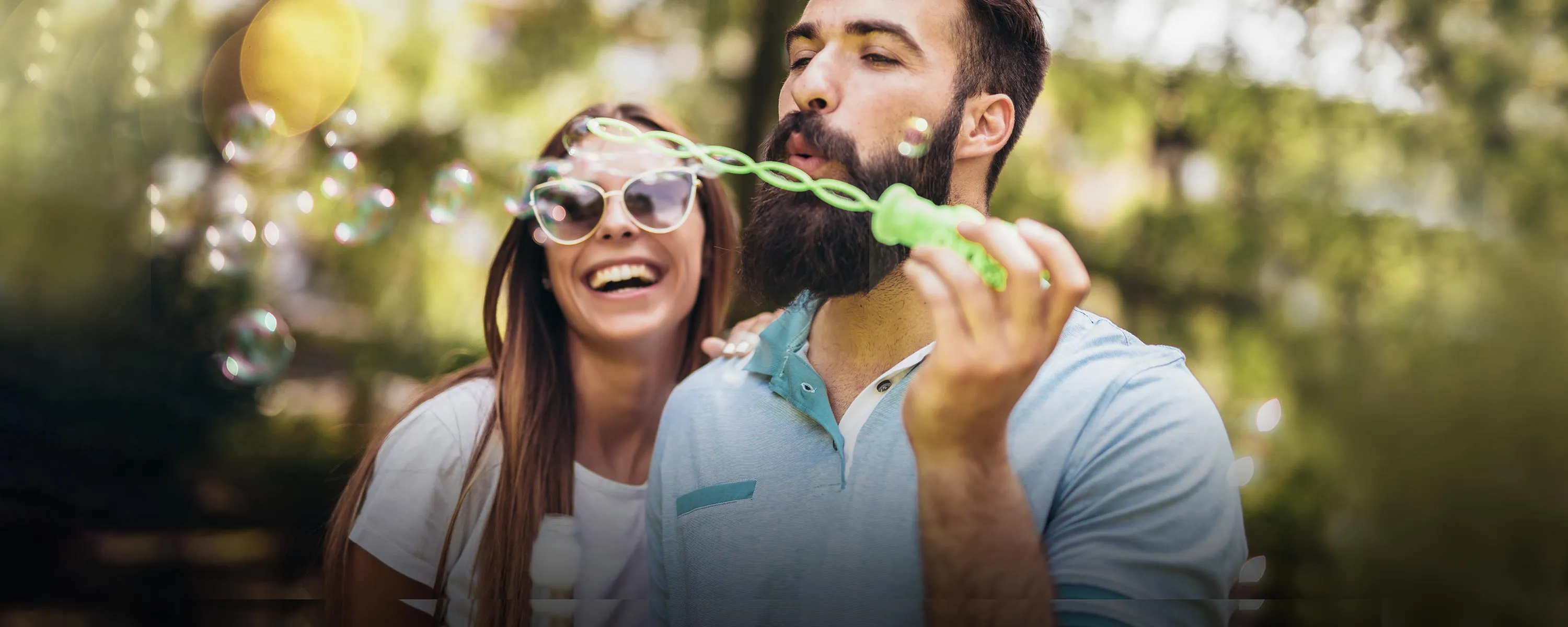 Couple blowing bubbles outside